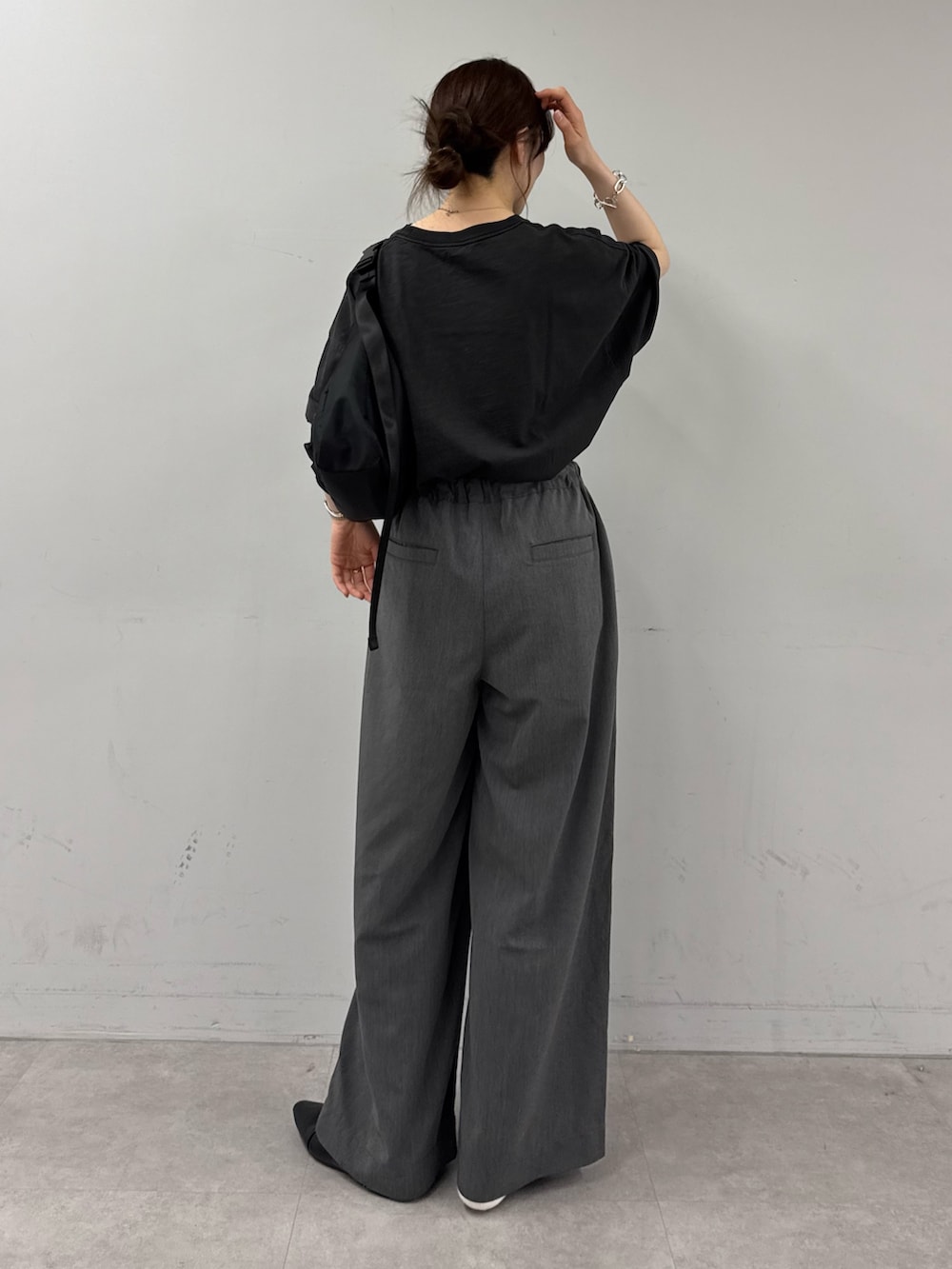 ブラック系のTシャツ/カットソー、ブラック系のショルダーバッグ、グレー系のデニムパンツを着用したレディースの春コーディネートの3枚目の写真