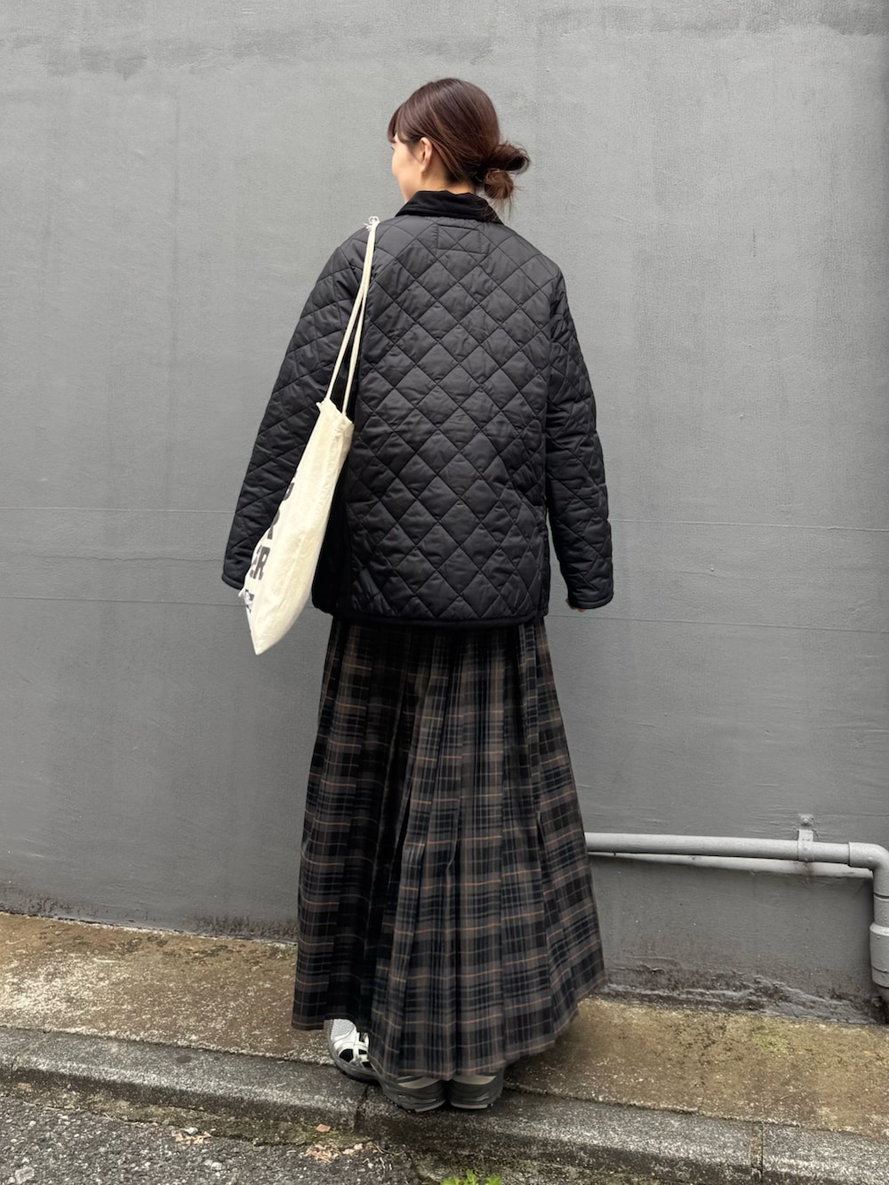 ブラック系のブルゾン、グレー系のスカートを着用したレディースの秋コーディネートの3枚目の写真