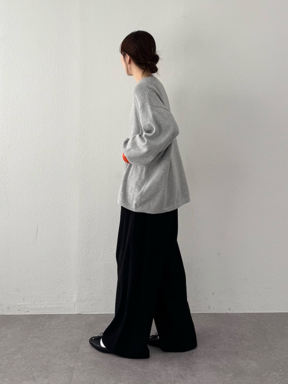 グレー系のニット/セーター、ブラック系のスラックスを着用したレディースの春コーディネートの2枚目の写真