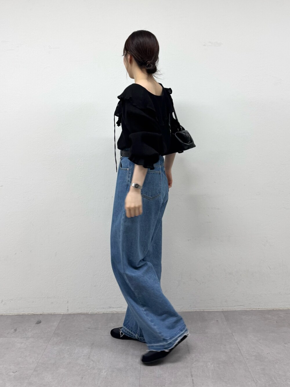 ブラック系のシャツ/ブラウス、ブルー系のデニムパンツ、ブラック系のトートバッグを着用したレディースの春コーディネートの2枚目の写真