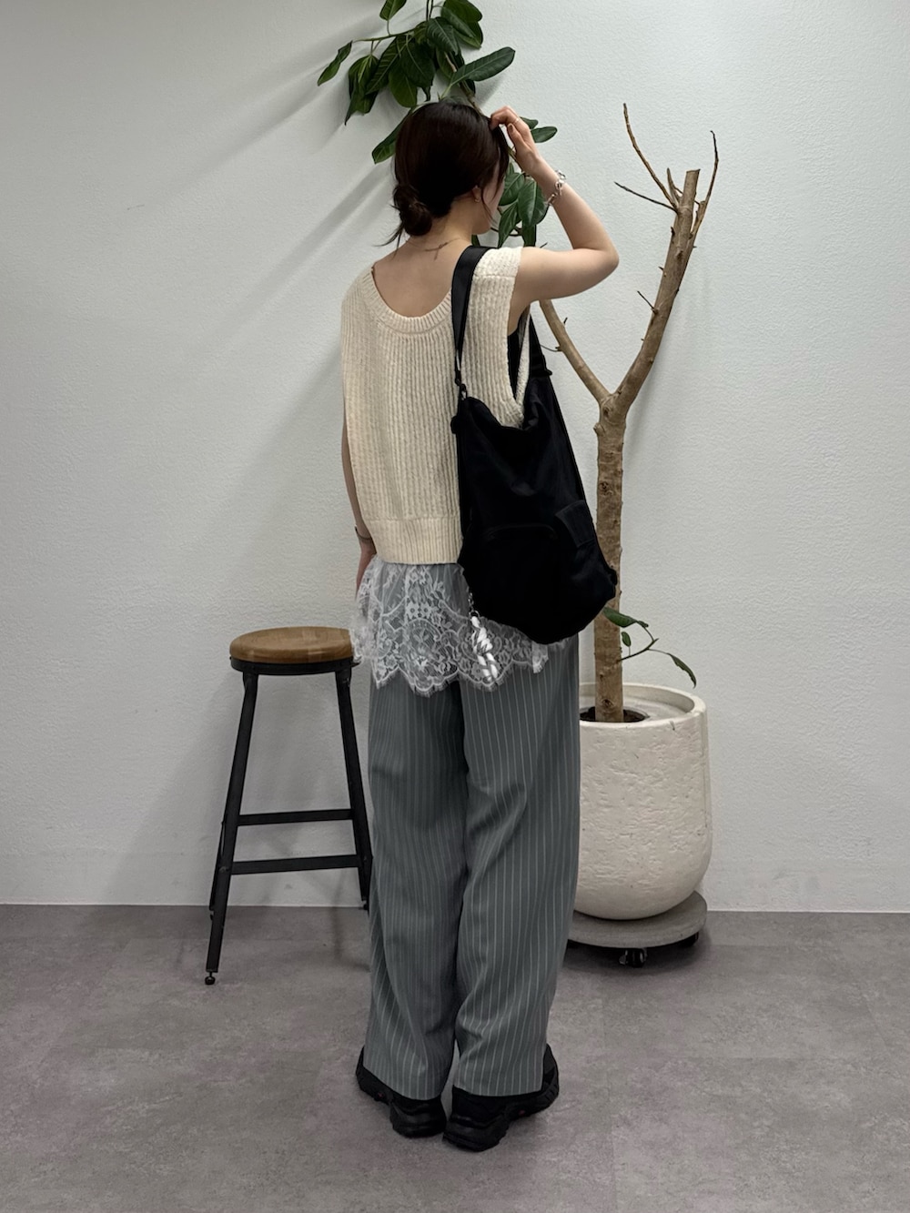 ホワイト系のベスト、グレー系のその他パンツ、ブラック系のトートバッグを着用したレディースの春コーディネートの3枚目の写真
