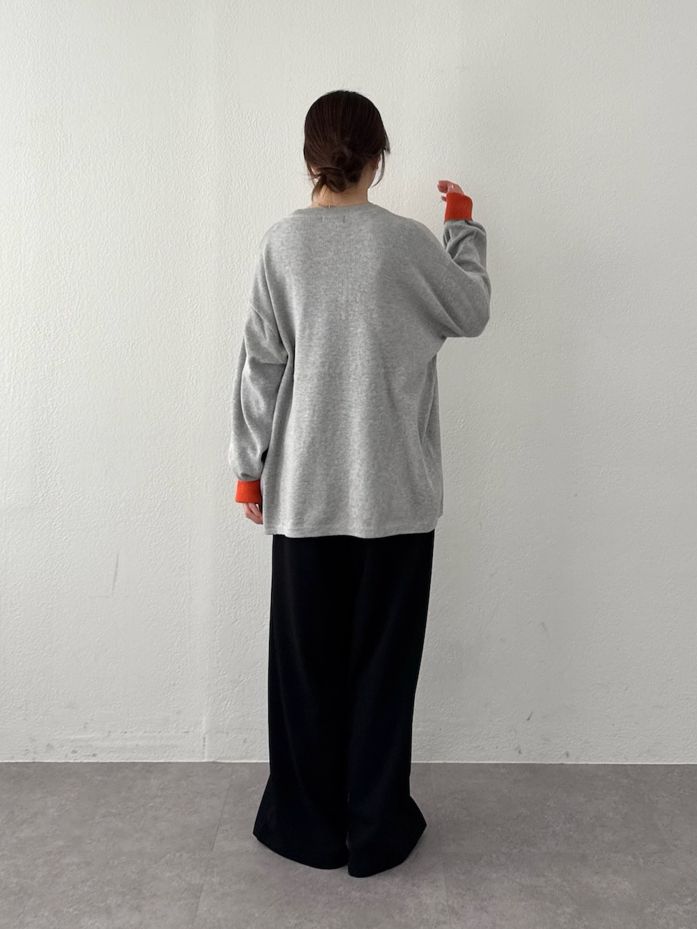 グレー系のニット/セーター、ブラック系のスラックスを着用したレディースの春コーディネートの3枚目の写真