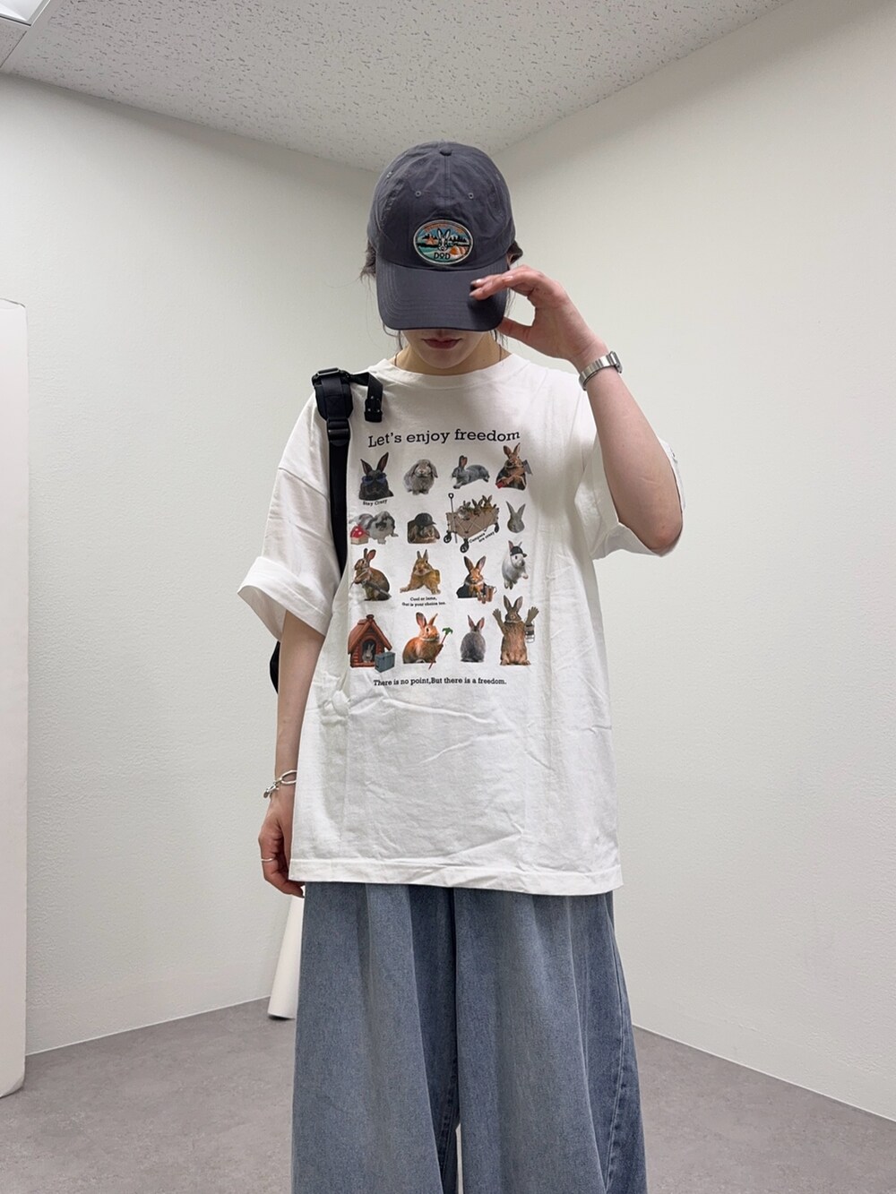 ホワイト系のTシャツ/カットソー、ブルー系のデニムパンツ、グレー系のキャップを着用したレディースの春コーディネートの4枚目の写真