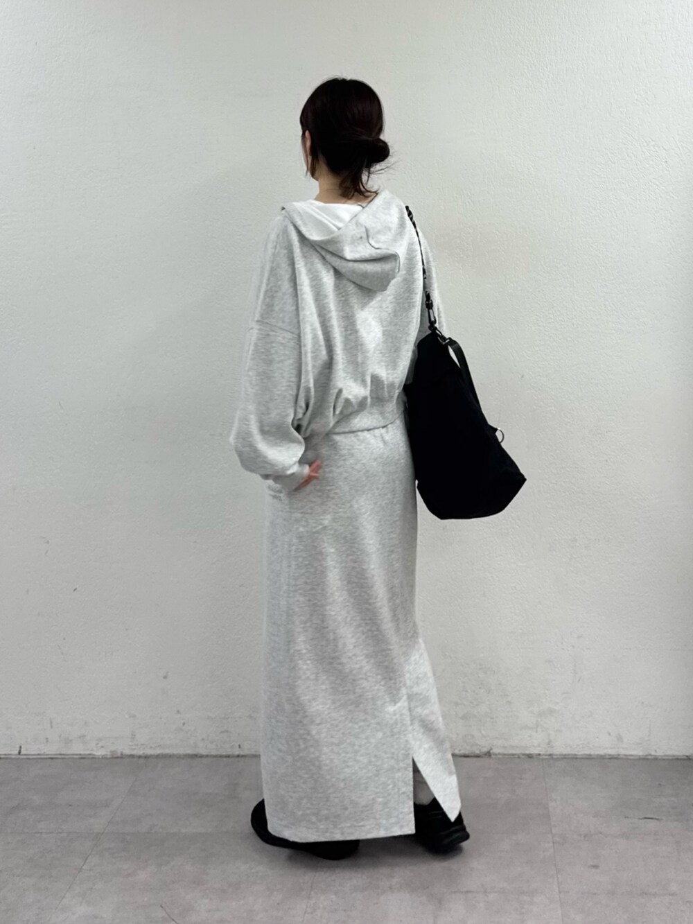 グレー系のパーカー、ブラック系のショルダーバッグを着用したレディースの春コーディネートの2枚目の写真