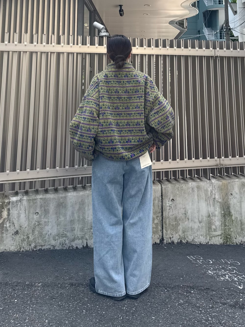 ベージュ系のブルゾン、ブルー系のデニムパンツを着用したレディースの秋コーディネートの3枚目の写真