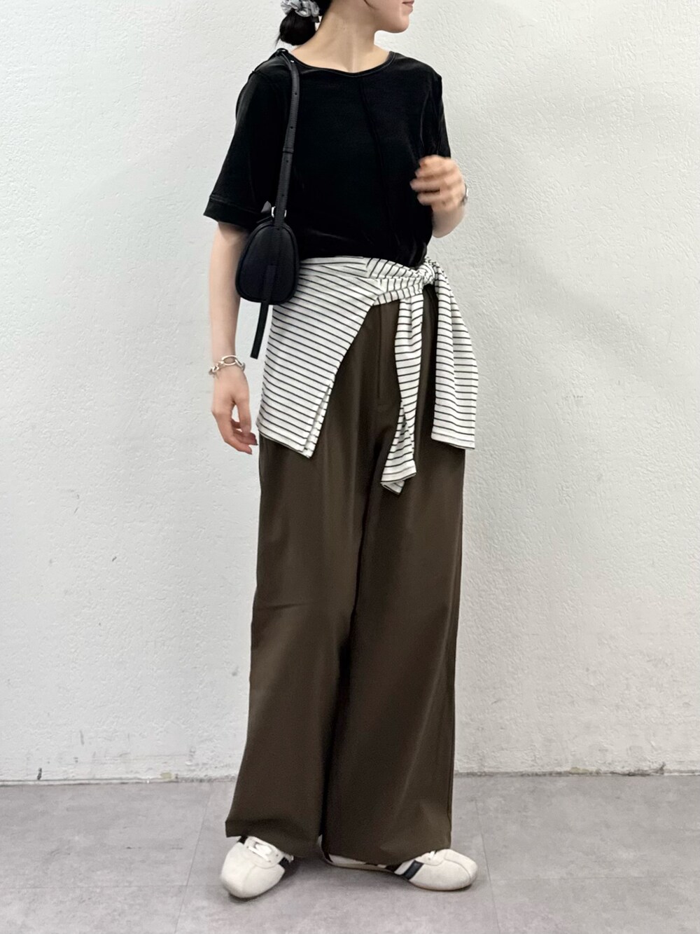 ブラウン系のTシャツ/カットソー、ホワイト系のTシャツ/カットソー、ブラウン系のスラックスを着用したレディースの秋コーディネートの3枚目の写真