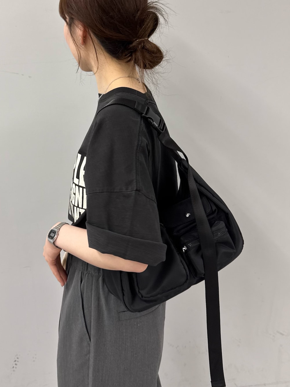 ブラック系のTシャツ/カットソー、ブラック系のショルダーバッグ、グレー系のデニムパンツを着用したレディースの春コーディネートの4枚目の写真