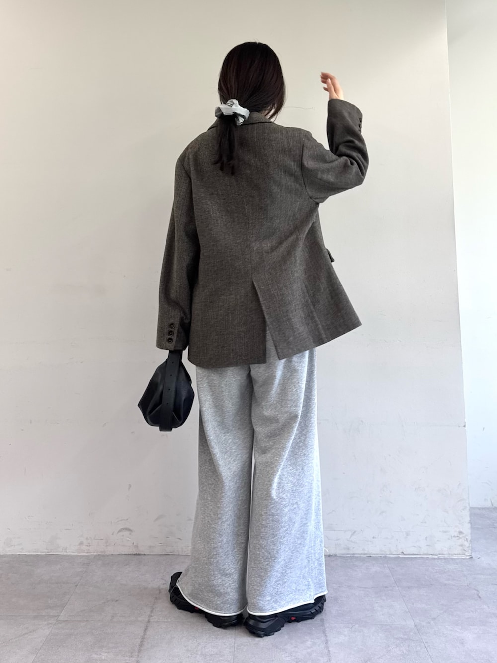 ブラウン系のテーラードジャケット、グレー系のスウェットパンツ、ブラック系のショルダーバッグを着用したレディースの夏コーディネートの3枚目の写真