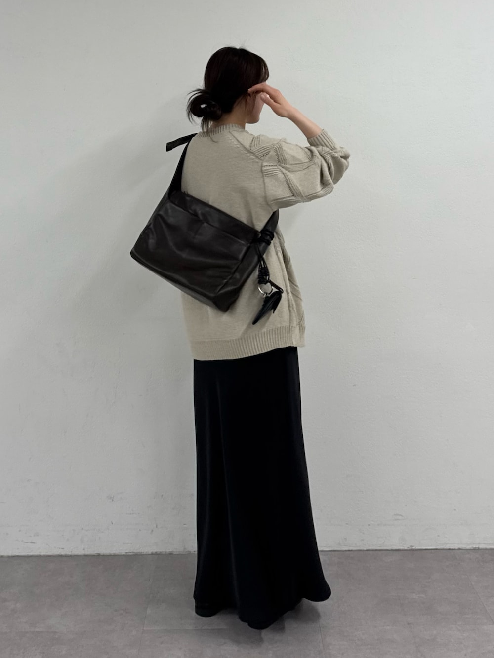 ベージュ系のカーディガン/ボレロ、ブラック系のスカートを着用したレディースの春コーディネートの3枚目の写真