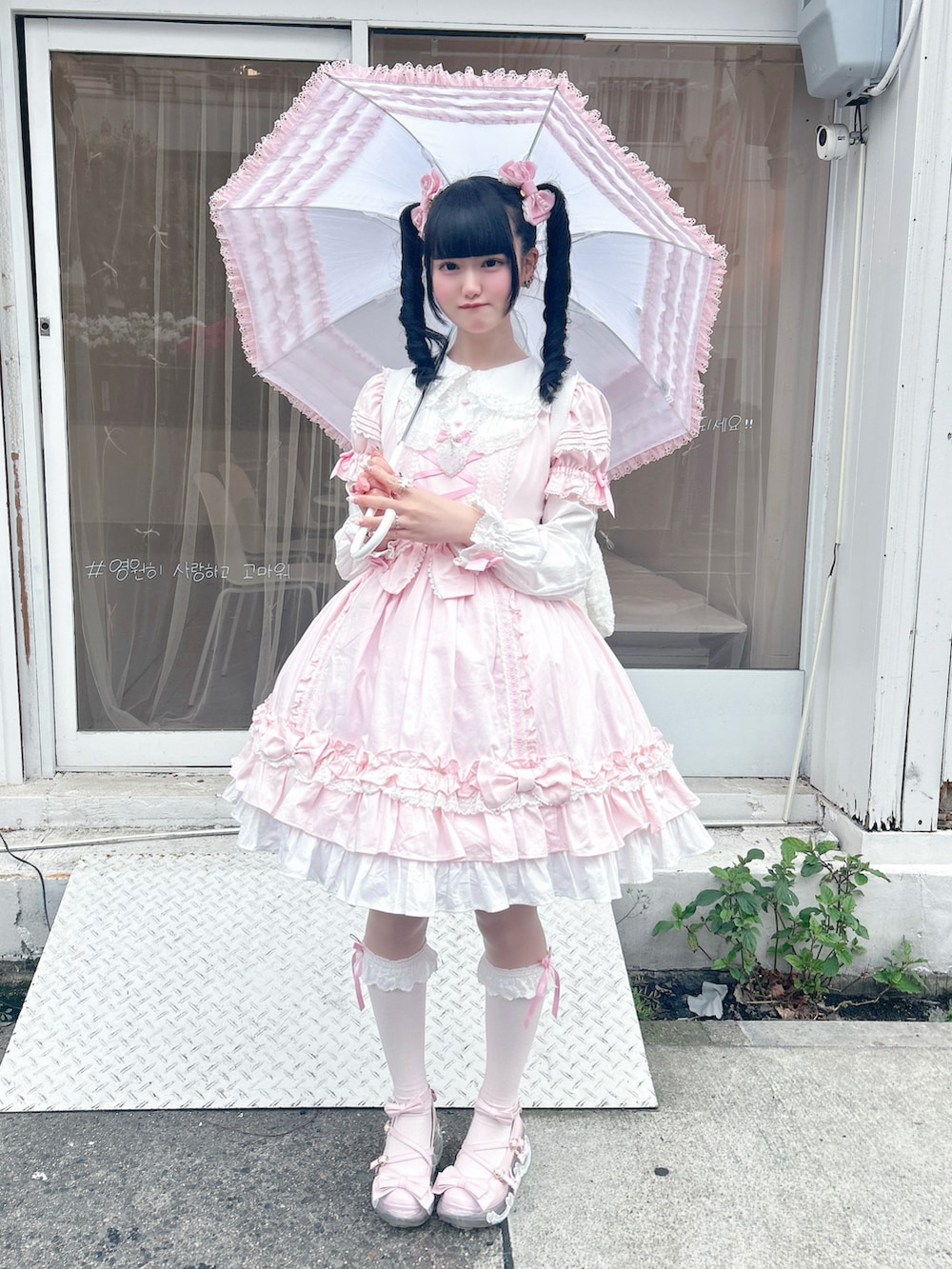 ピンク系のシューズ、ホワイト系のバックパック/リュック、ピンク系のワンピースを着用したレディースの春コーディネートの2枚目の写真