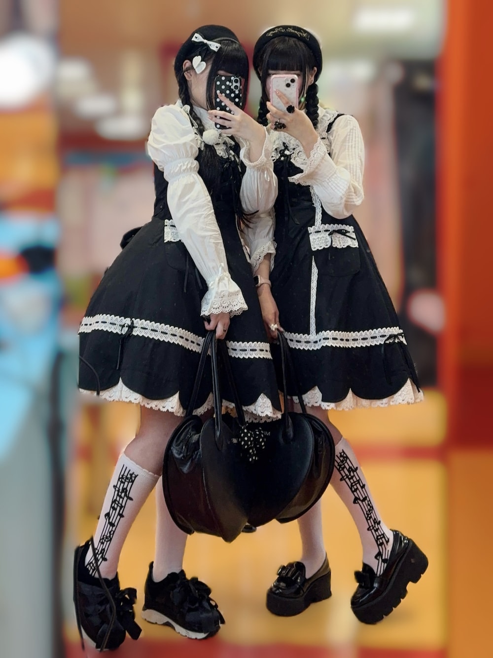 ブラック系のジャンパースカート、ホワイト系のシャツ/ブラウス、ブラック系のハンドバッグを着用したレディースの秋コーディネートの2枚目の写真