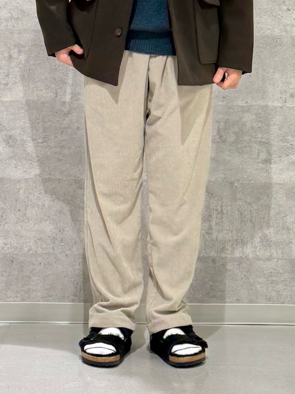 ブラウン系のその他アウター、グリーン系のニット/セーター、ベージュ系のその他パンツを着用したメンズの秋コーディネートの7枚目の写真