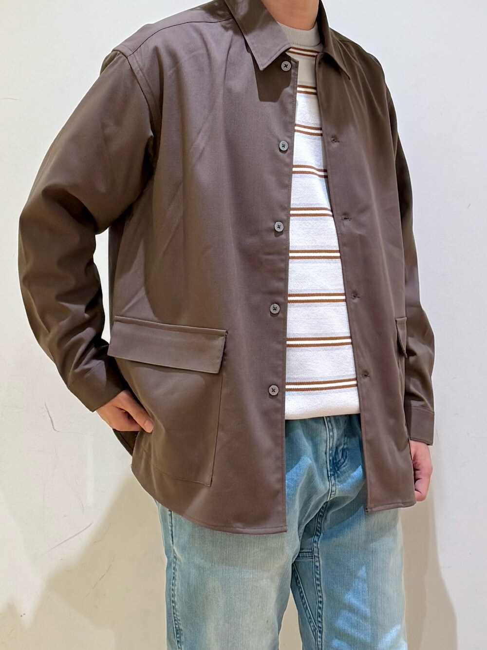 ブラウン系のシャツ/ブラウス、グレー系のニット/セーター、ブルー系のその他パンツを着用したメンズの冬コーディネートの4枚目の写真