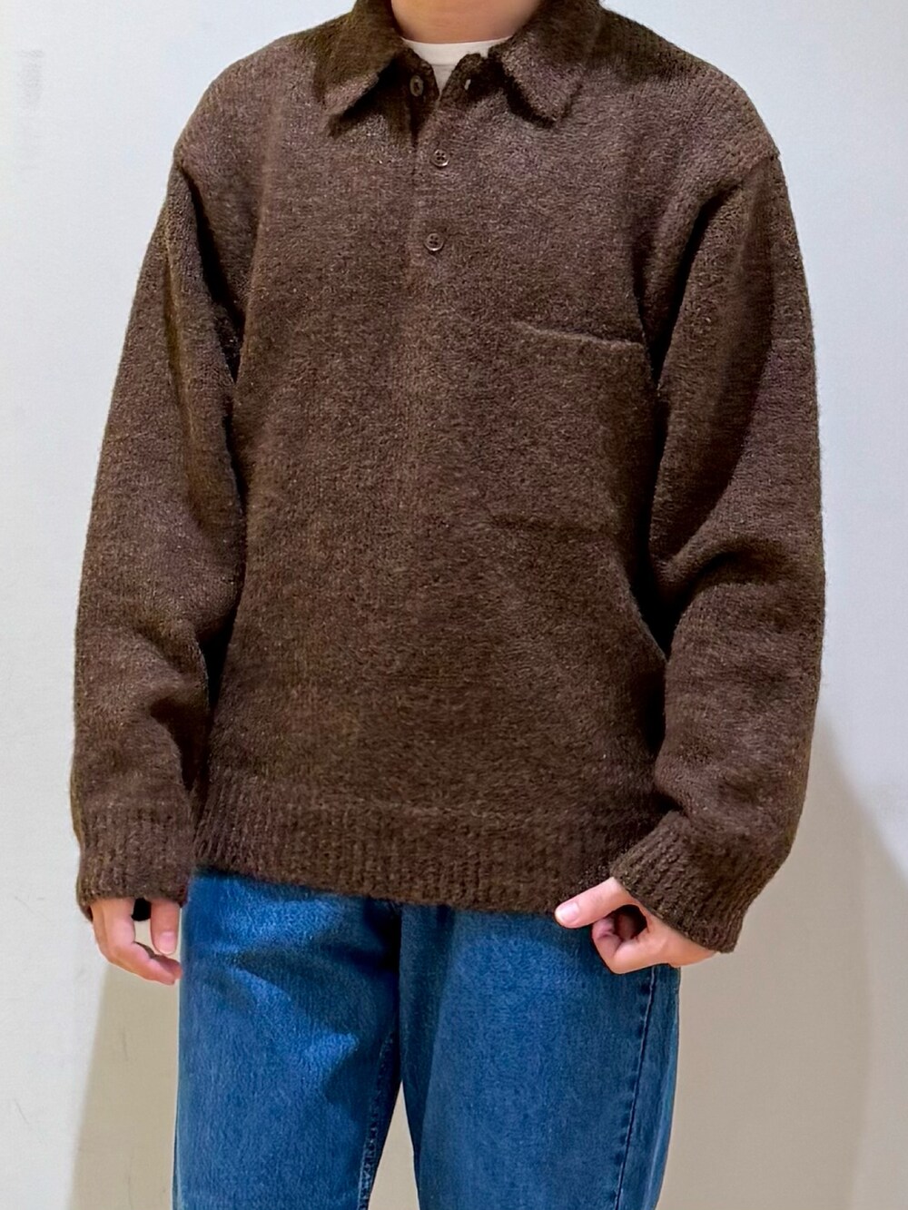 ブラウン系のニット/セーター、ブルー系のデニムパンツ、ブラック系のサンダルを着用したメンズの秋コーディネートの4枚目の写真