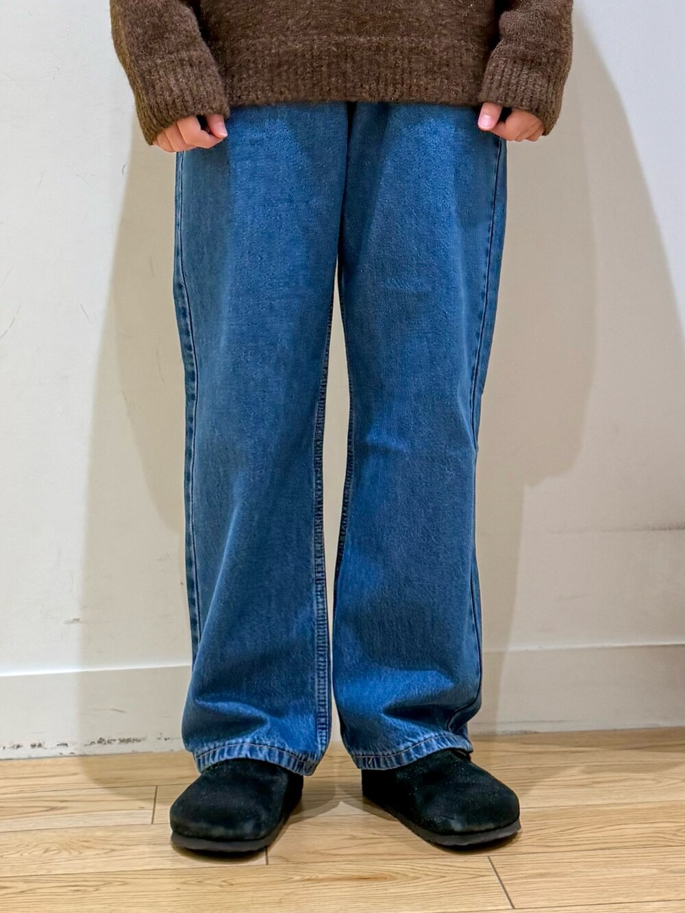 ブラウン系のニット/セーター、ブルー系のデニムパンツ、ブラック系のサンダルを着用したメンズの秋コーディネートの6枚目の写真