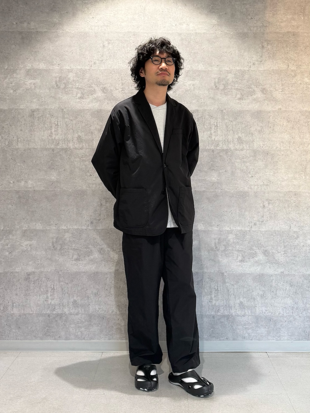 ブラック系のその他アウター、グレー系のTシャツ/カットソー、ブラック系のその他パンツを着用したメンズの春コーディネートの2枚目の写真