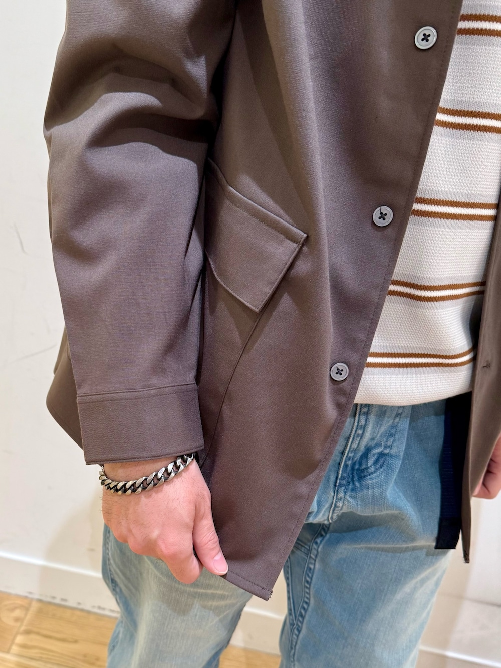 ブラウン系のシャツ/ブラウス、グレー系のニット/セーター、ブルー系のその他パンツを着用したメンズの冬コーディネートの6枚目の写真