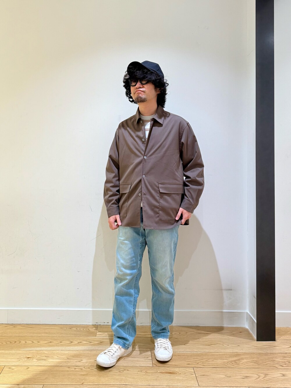 ブラウン系のシャツ/ブラウス、グレー系のニット/セーター、ブルー系のその他パンツを着用したメンズの冬コーディネートの2枚目の写真