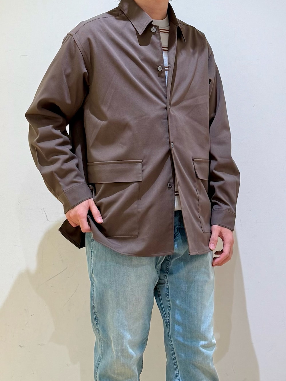 ブラウン系のシャツ/ブラウス、グレー系のニット/セーター、ブルー系のその他パンツを着用したメンズの冬コーディネートの5枚目の写真