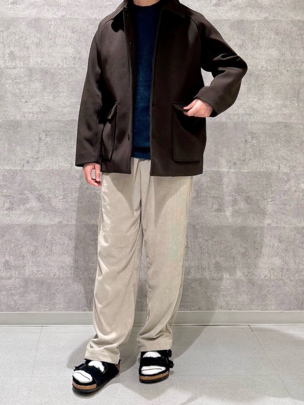 ブラウン系のその他アウター、グリーン系のニット/セーター、ベージュ系のその他パンツを着用したメンズの秋コーディネートの3枚目の写真