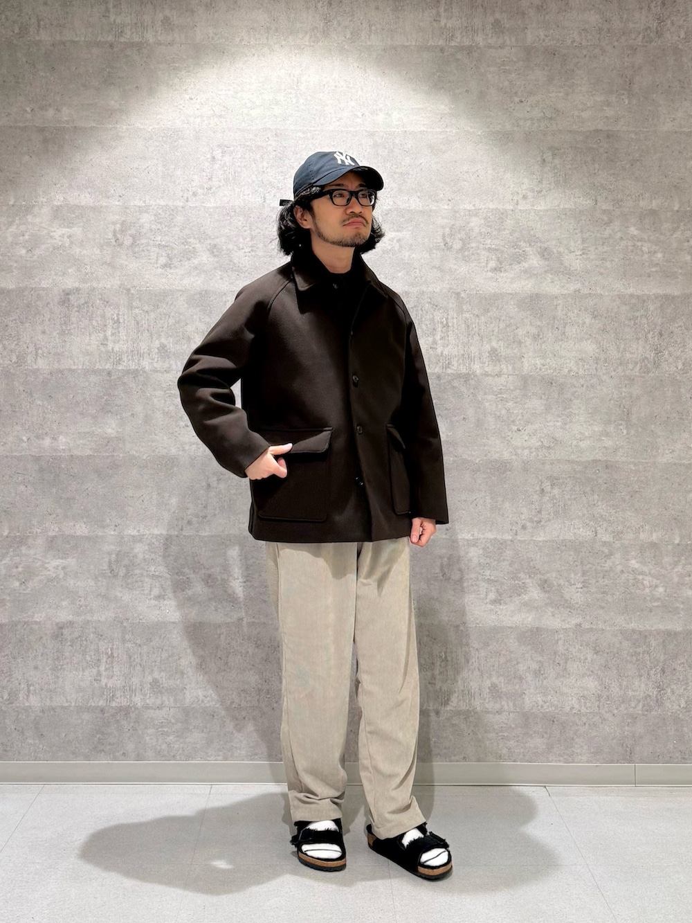 ブラウン系のその他アウター、グリーン系のニット/セーター、ベージュ系のその他パンツを着用したメンズの秋コーディネートの2枚目の写真