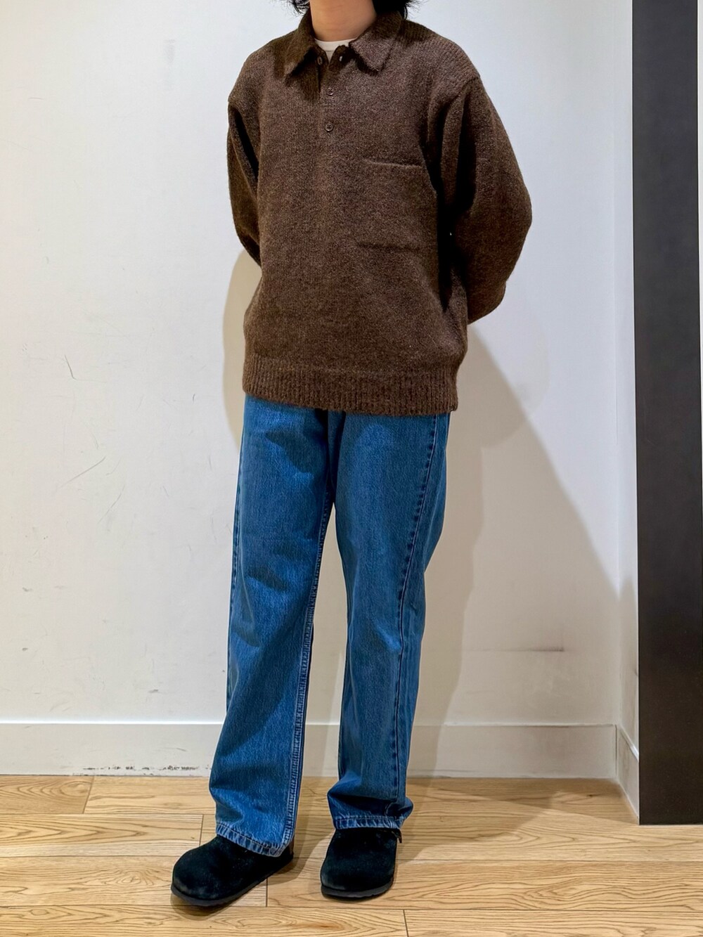 ブラウン系のニット/セーター、ブルー系のデニムパンツ、ブラック系のサンダルを着用したメンズの秋コーディネートの3枚目の写真