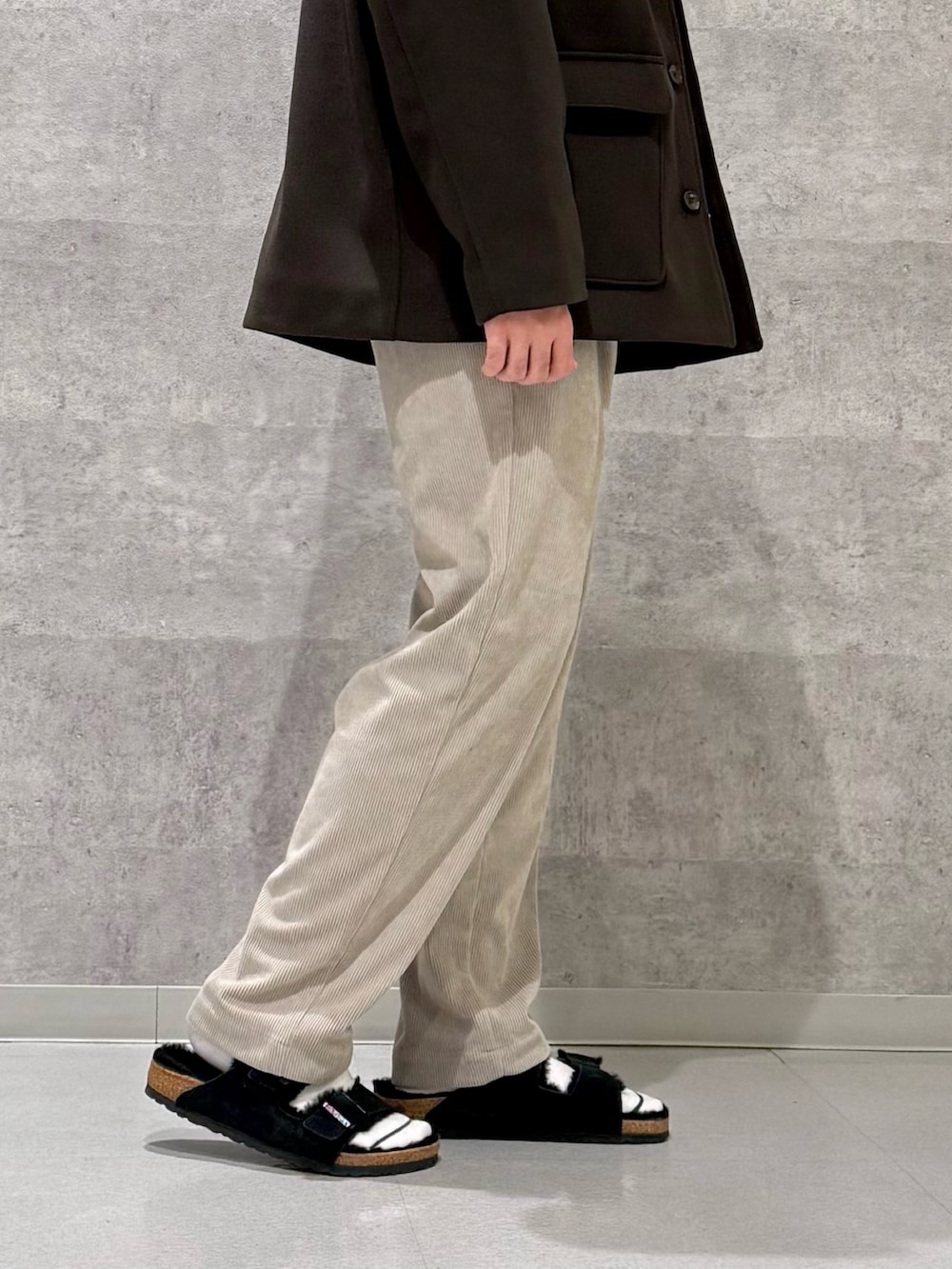 ブラウン系のその他アウター、グリーン系のニット/セーター、ベージュ系のその他パンツを着用したメンズの秋コーディネートの9枚目の写真