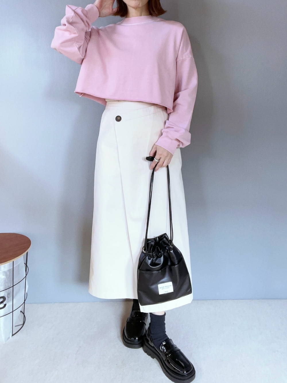 ピンク系のスウェット、ホワイト系のスカート、ブラック系のローファーを着用したレディースの冬コーディネートの2枚目の写真