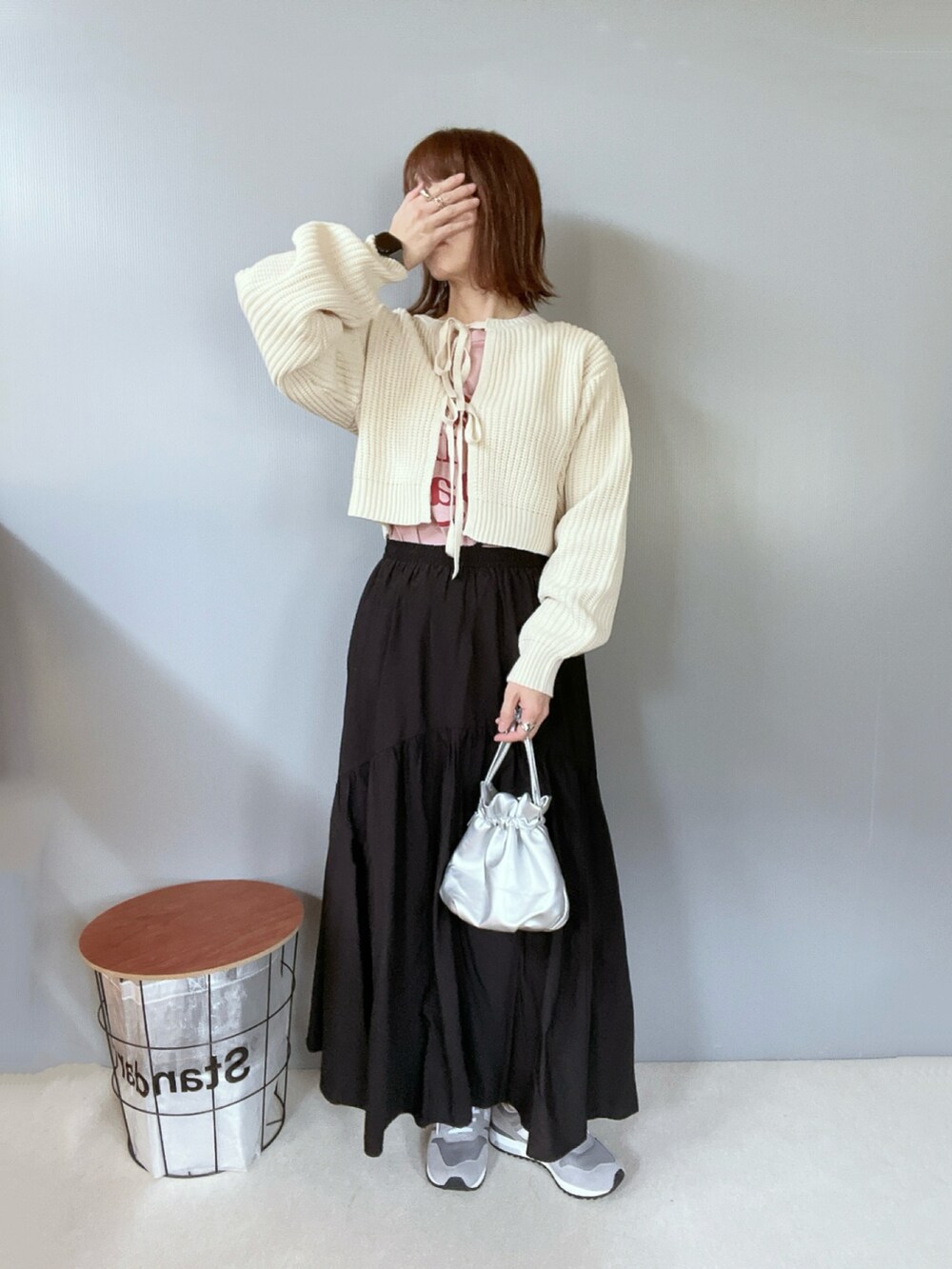 ホワイト系のニット/セーター、ブラック系のスカート、グレー系のスニーカーを着用したレディースの冬コーディネートの2枚目の写真