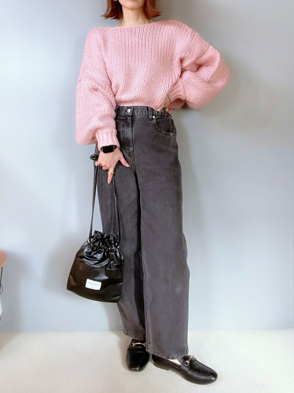 ブラック系のデニムパンツ、ピンク系のニット/セーター、ブラック系のシューズを着用したレディースの冬コーディネートの2枚目の写真