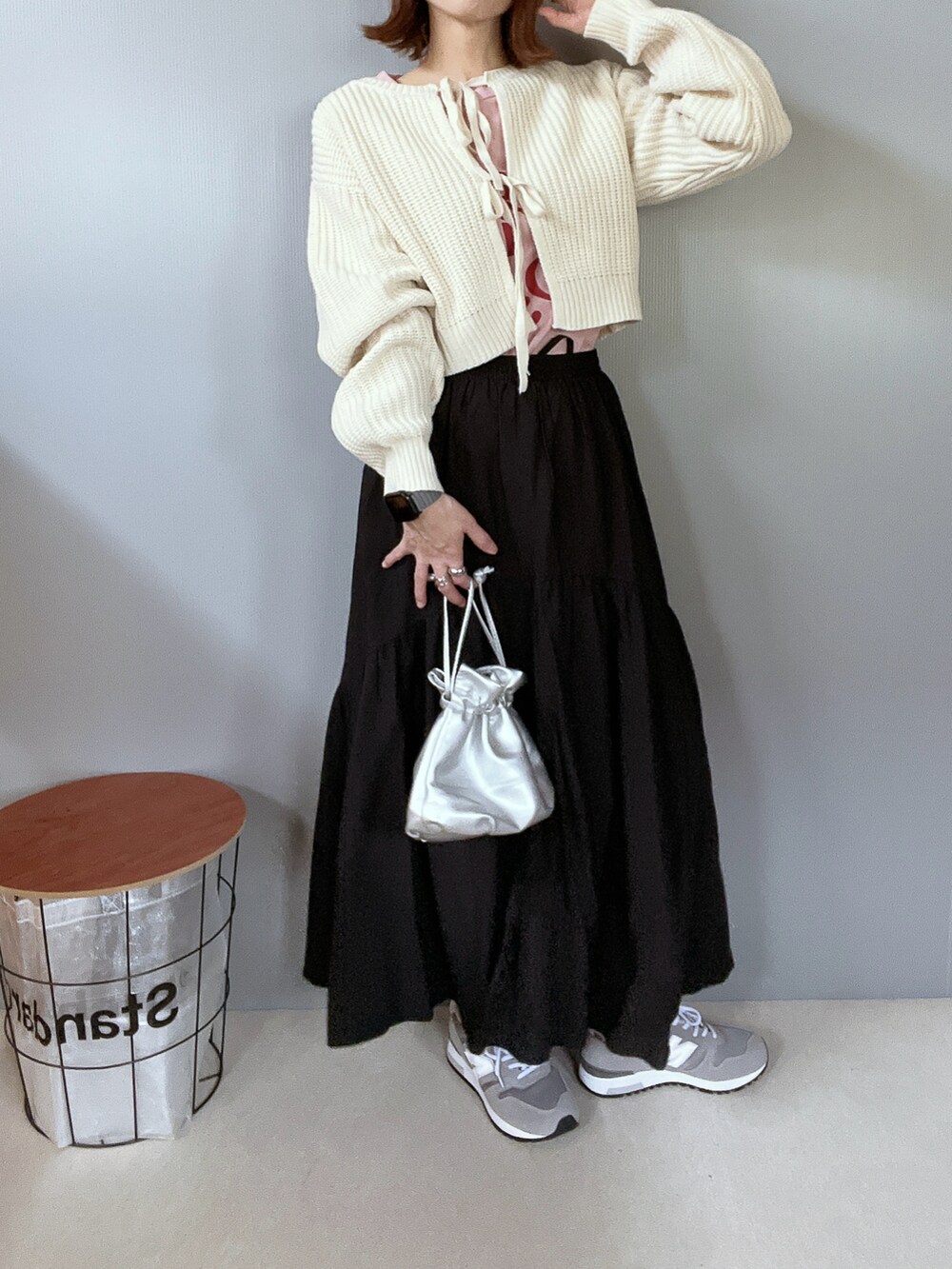 ホワイト系のニット/セーター、ブラック系のスカート、グレー系のスニーカーを着用したレディースの冬コーディネートの3枚目の写真