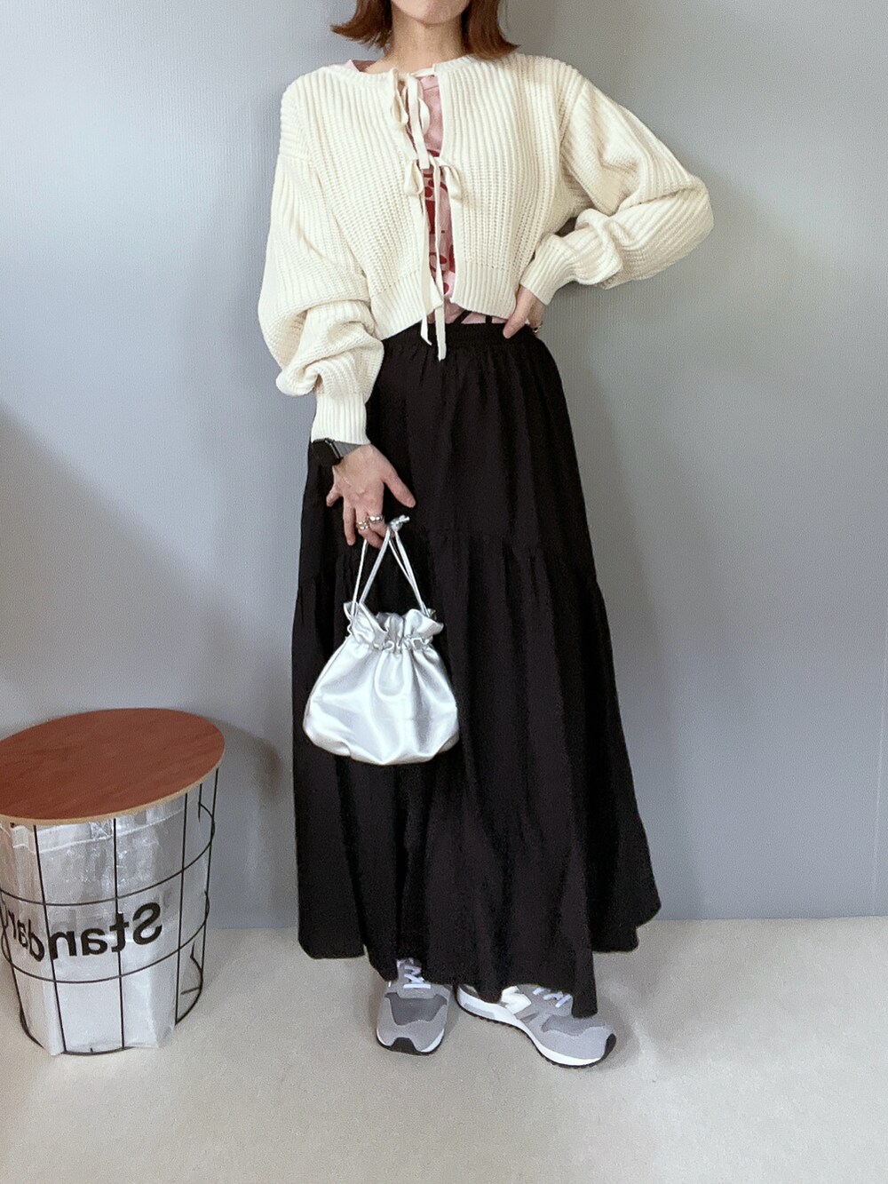 ホワイト系のニット/セーター、ブラック系のスカート、グレー系のスニーカーを着用したレディースの冬コーディネートの4枚目の写真