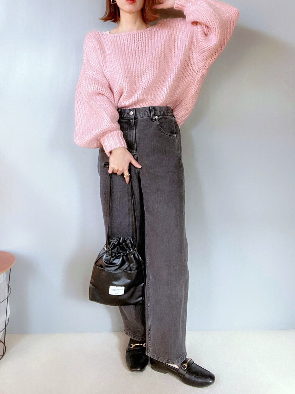 ブラック系のデニムパンツ、ピンク系のニット/セーター、ブラック系のシューズを着用したレディースの冬コーディネートの3枚目の写真