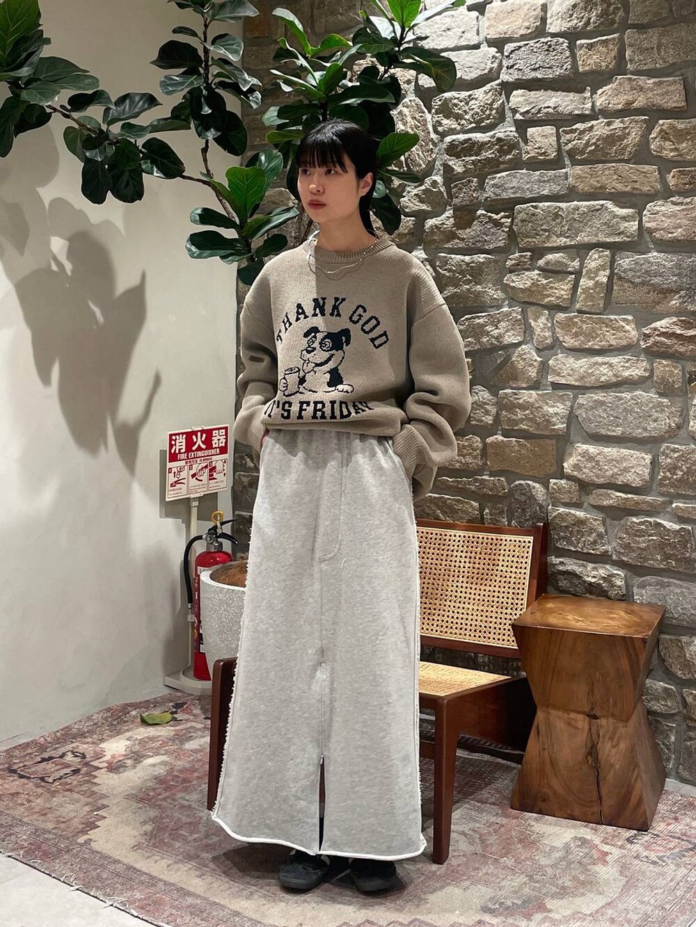 ベージュ系のニット/セーター、グレー系のスカートを着用したレディースの冬コーディネートの2枚目の写真