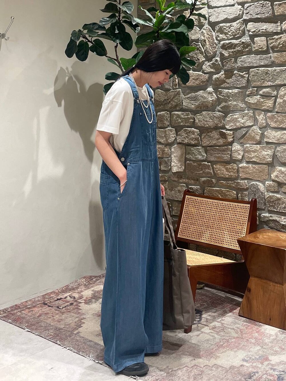 ホワイト系のTシャツ/カットソー、グリーン系のトートバッグ、ブルー系のサロペット/オーバーオールを着用したレディースの春コーディネートの2枚目の写真