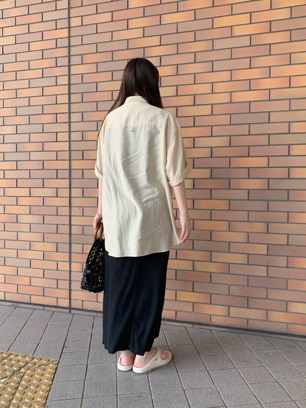 ホワイト系のシャツ/ブラウス、ブラック系のワンピース、ホワイト系のサンダルを着用したレディースの夏コーディネートの2枚目の写真