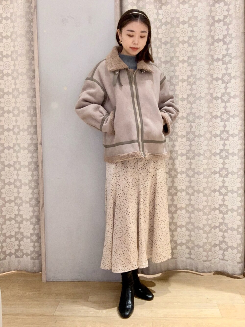 ブラウン系のブルゾン、ベージュ系のスカート、ブラック系のブーツを着用したレディースの秋コーディネートの2枚目の写真