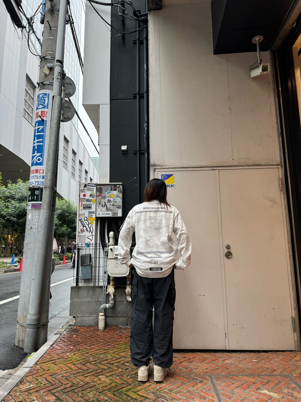 ブラック系のカーゴパンツ、ホワイト系のTシャツ/カットソーを着用したレディースの秋コーディネートの2枚目の写真