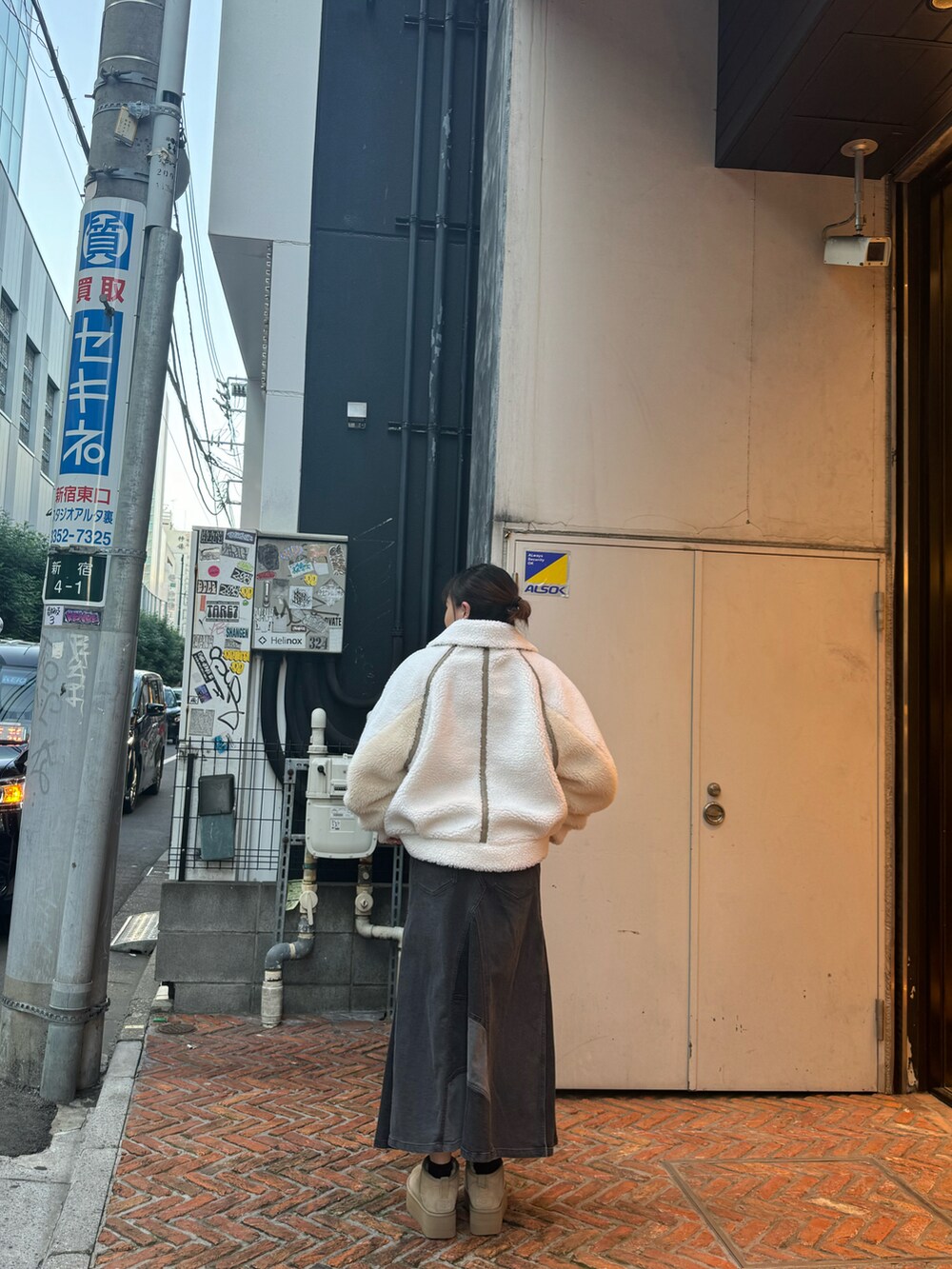 ブラック系のTシャツ/カットソー、ホワイト系のブルゾン、ブラック系のデニムスカートを着用したレディースの秋コーディネートの2枚目の写真