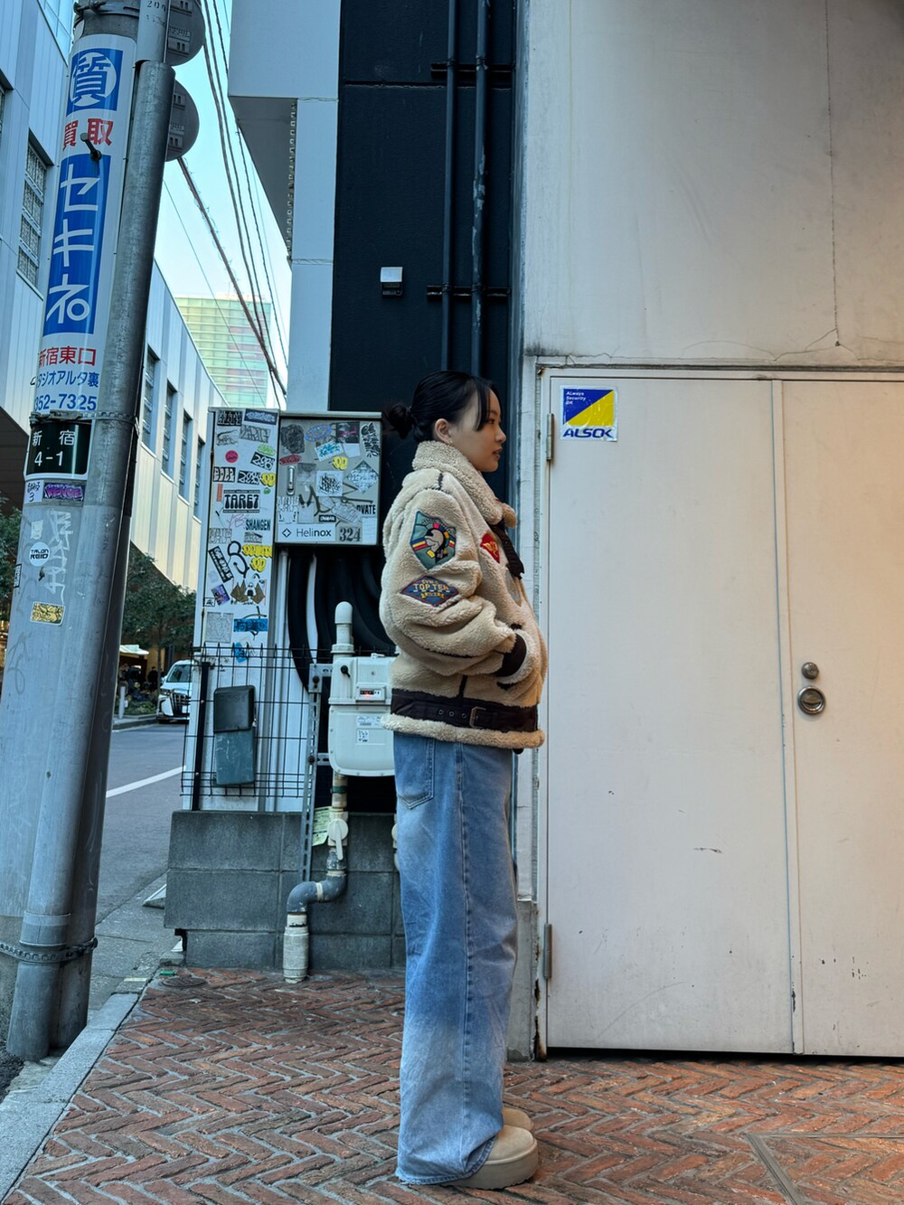 ベージュ系のミリタリージャケットを着用したレディースの冬コーディネートの2枚目の写真