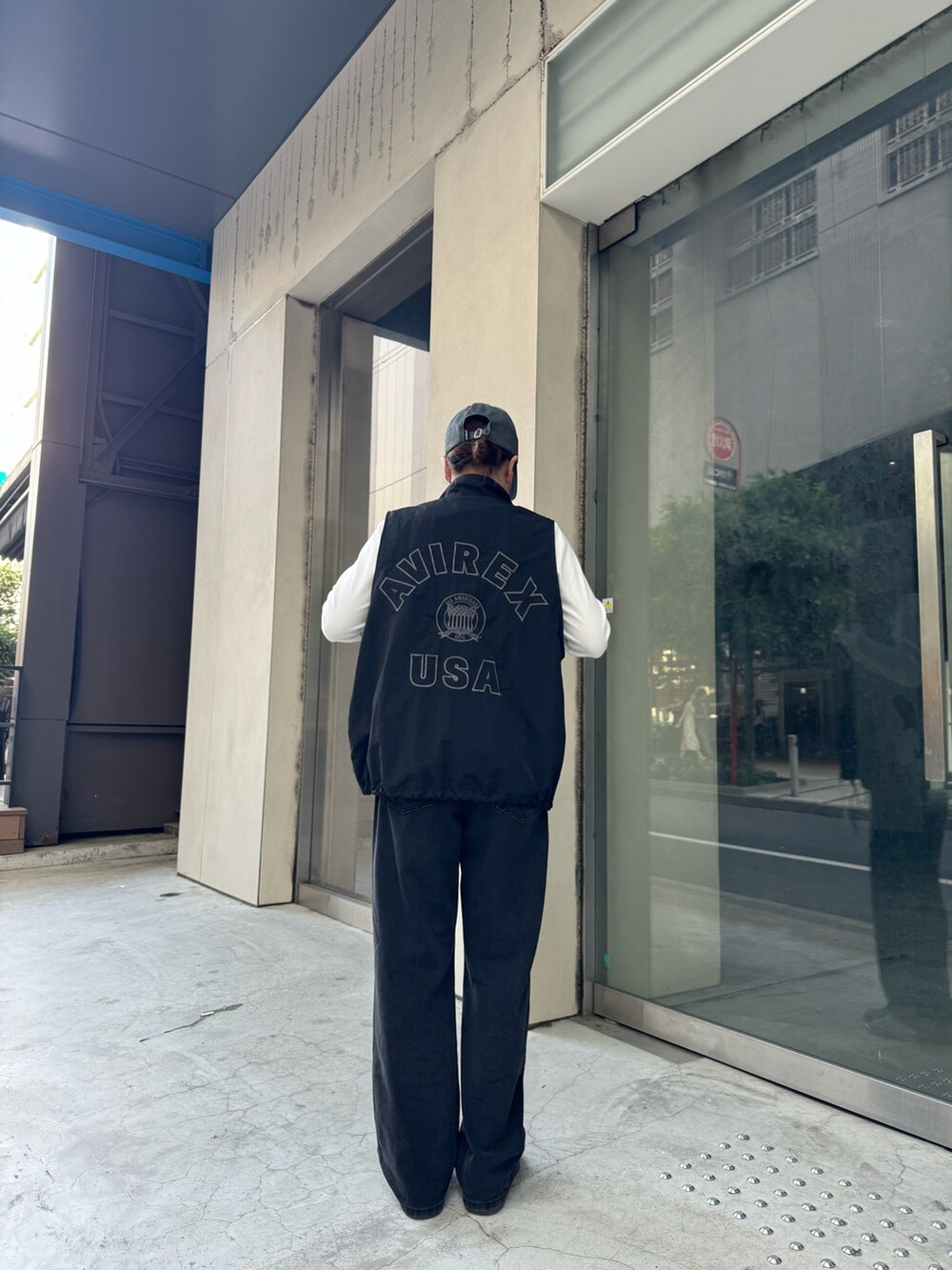 ブラック系のベスト、ホワイト系のTシャツ/カットソー、ブラック系のキャップを着用したレディースの秋コーディネートの2枚目の写真