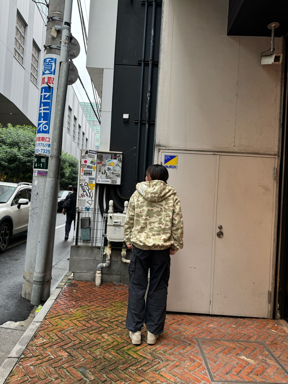 ベージュ系のパーカー、ブラック系のカーゴパンツを着用したレディースの秋コーディネートの2枚目の写真