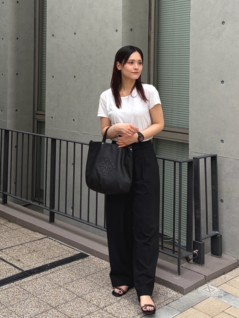 ブラック系のトートバッグを着用したレディースの夏コーディネートの2枚目の写真