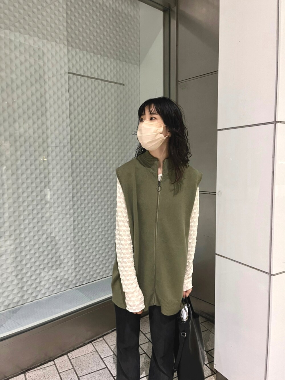 グリーン系のベスト、ホワイト系のTシャツ/カットソー、ブラック系のベストを着用したレディースの秋コーディネートの3枚目の写真