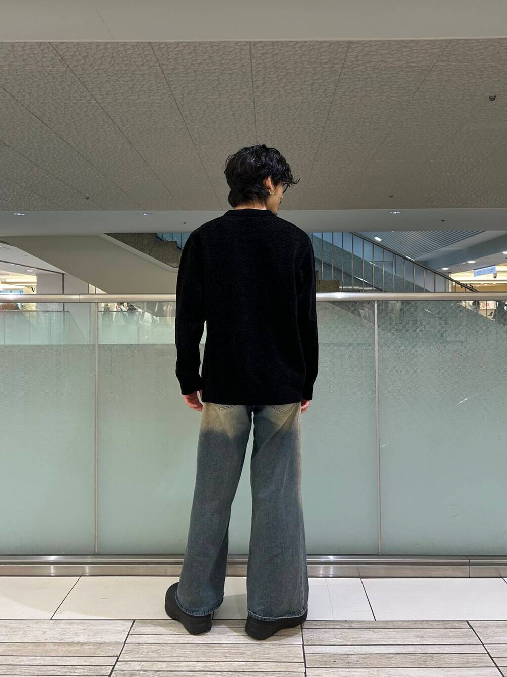 ブルー系のデニムパンツ、ブラック系のニット/セーターを着用したメンズの冬コーディネートの2枚目の写真