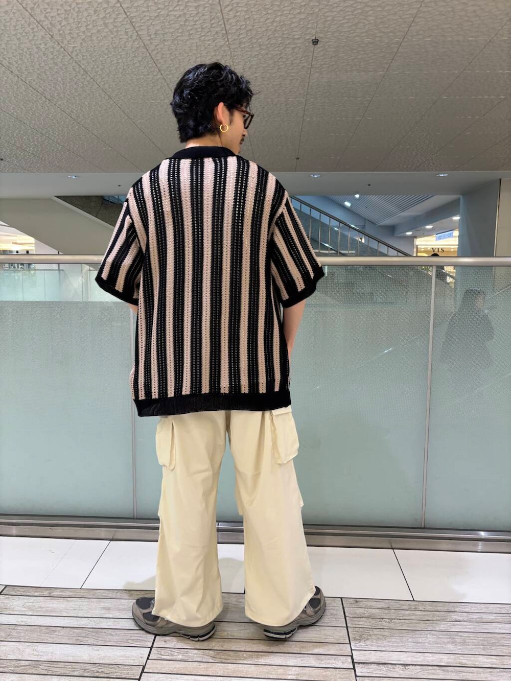 ホワイト系のTシャツ/カットソー、ベージュ系のその他パンツ、ブラック系のニット/セーターを着用したメンズの春コーディネートの2枚目の写真