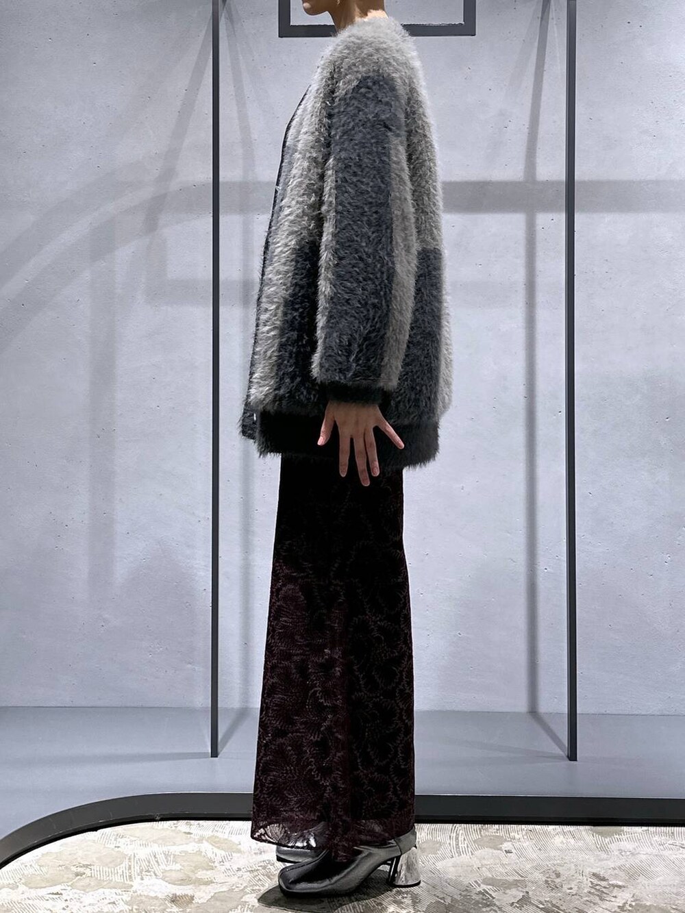 グレー系のカーディガン/ボレロ、シルバー系のブーツ、ブラック系のニット/セーターを着用したレディースの秋コーディネートの2枚目の写真