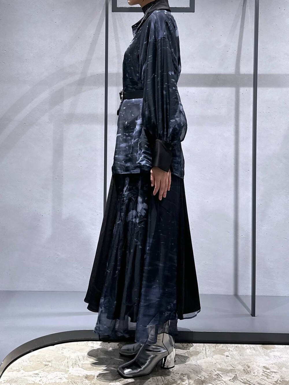 シルバー系のブーツ、ブラック系のニット/セーター、ブラック系のスカートを着用したレディースの秋コーディネートの2枚目の写真