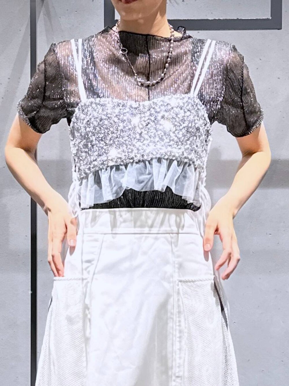 シルバー系のチューブトップ、ブラック系のTシャツ/カットソー、ホワイト系のスカートを着用したレディースの夏コーディネートの5枚目の写真