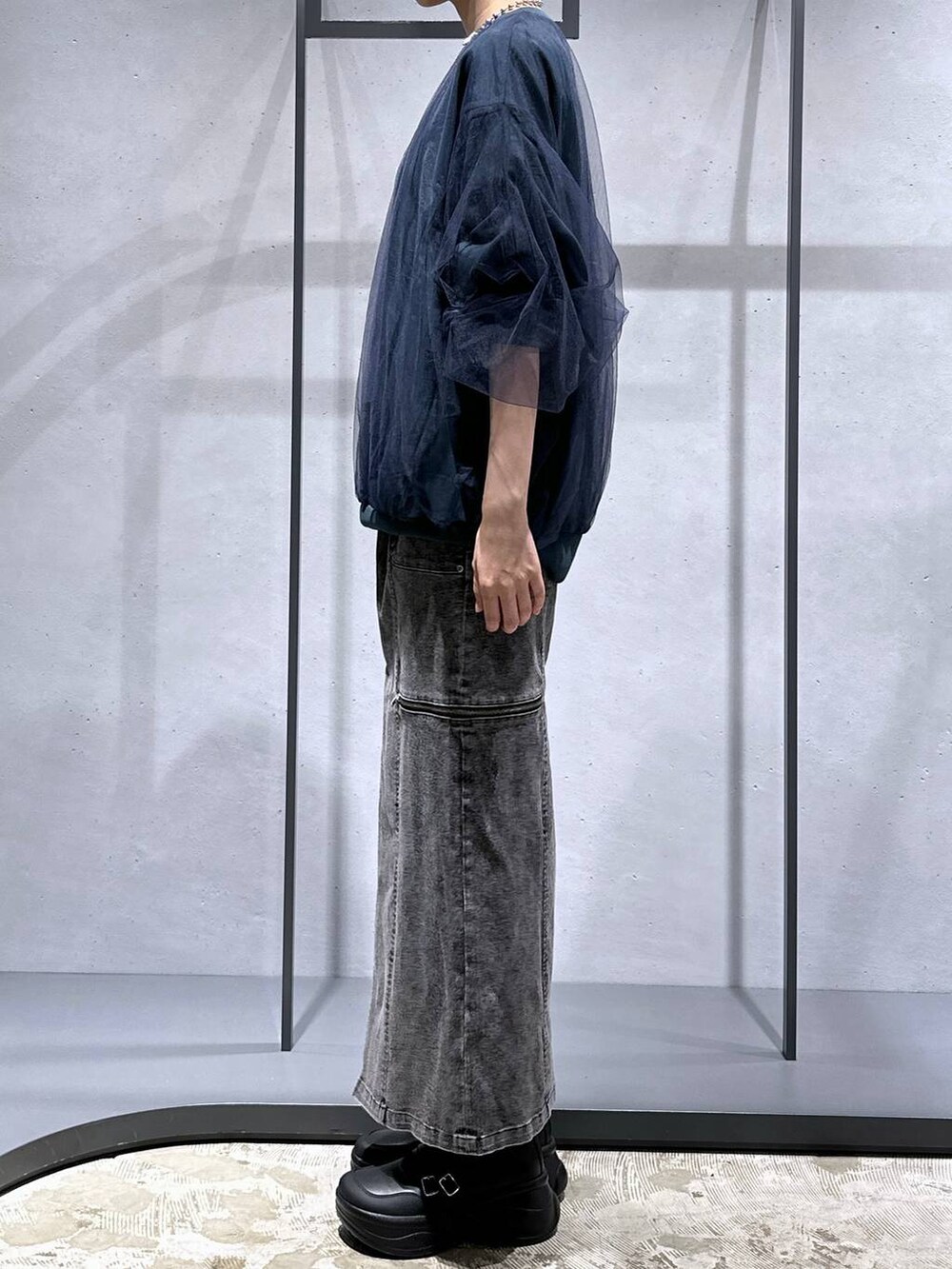 グリーン系のスウェット、ブラック系のブーツ、ブラック系のスカートを着用したレディースの夏コーディネートの2枚目の写真